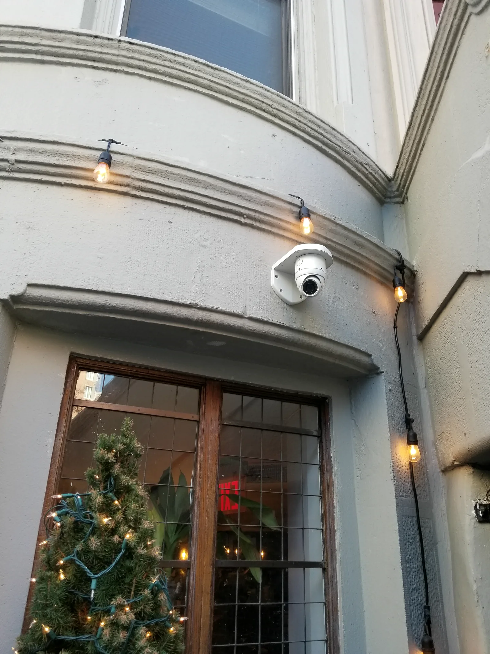 Exterior security camera installed above a commercial entrance